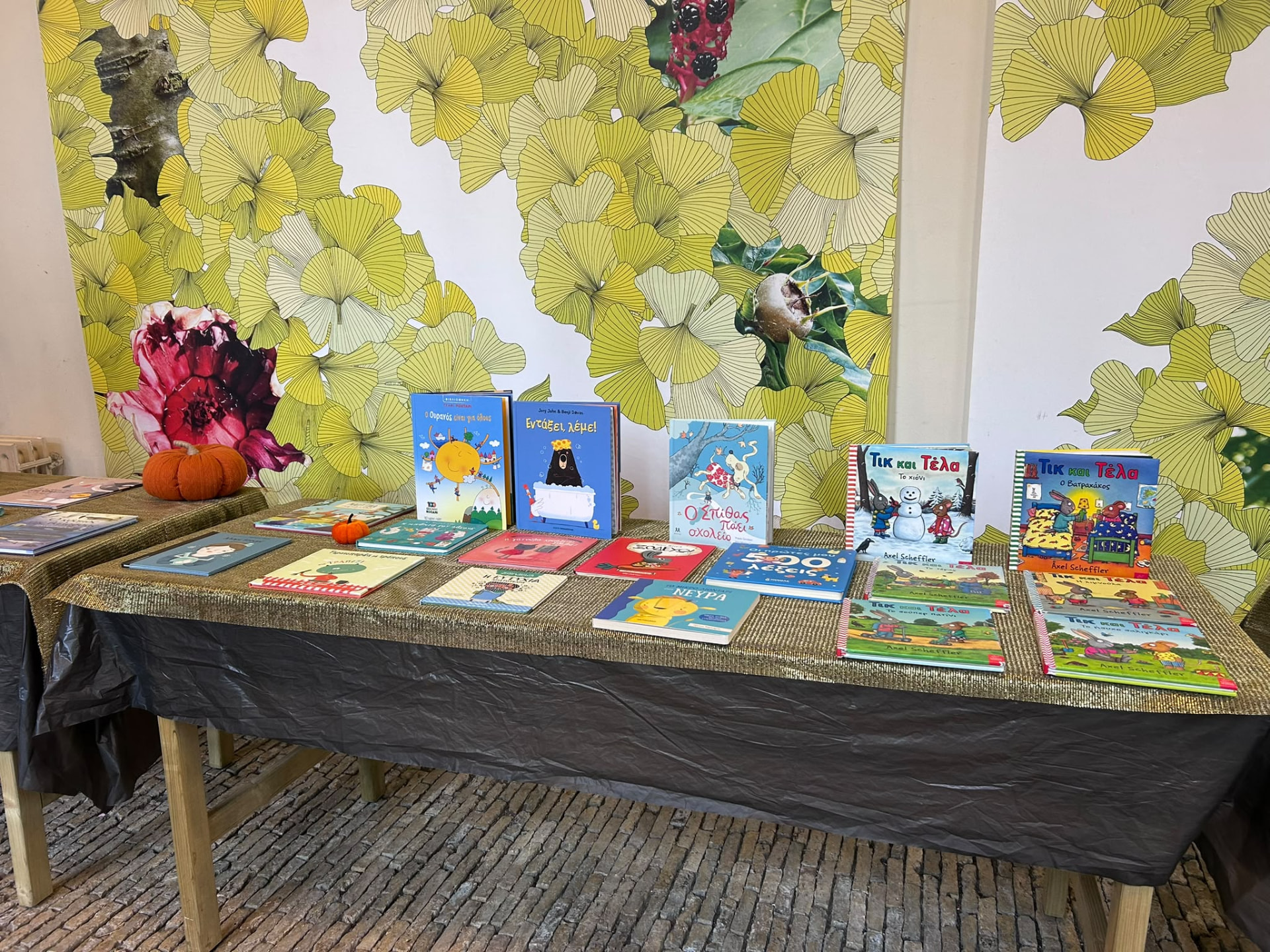 A table of colourful Greek children's picture books displayed at the book swap